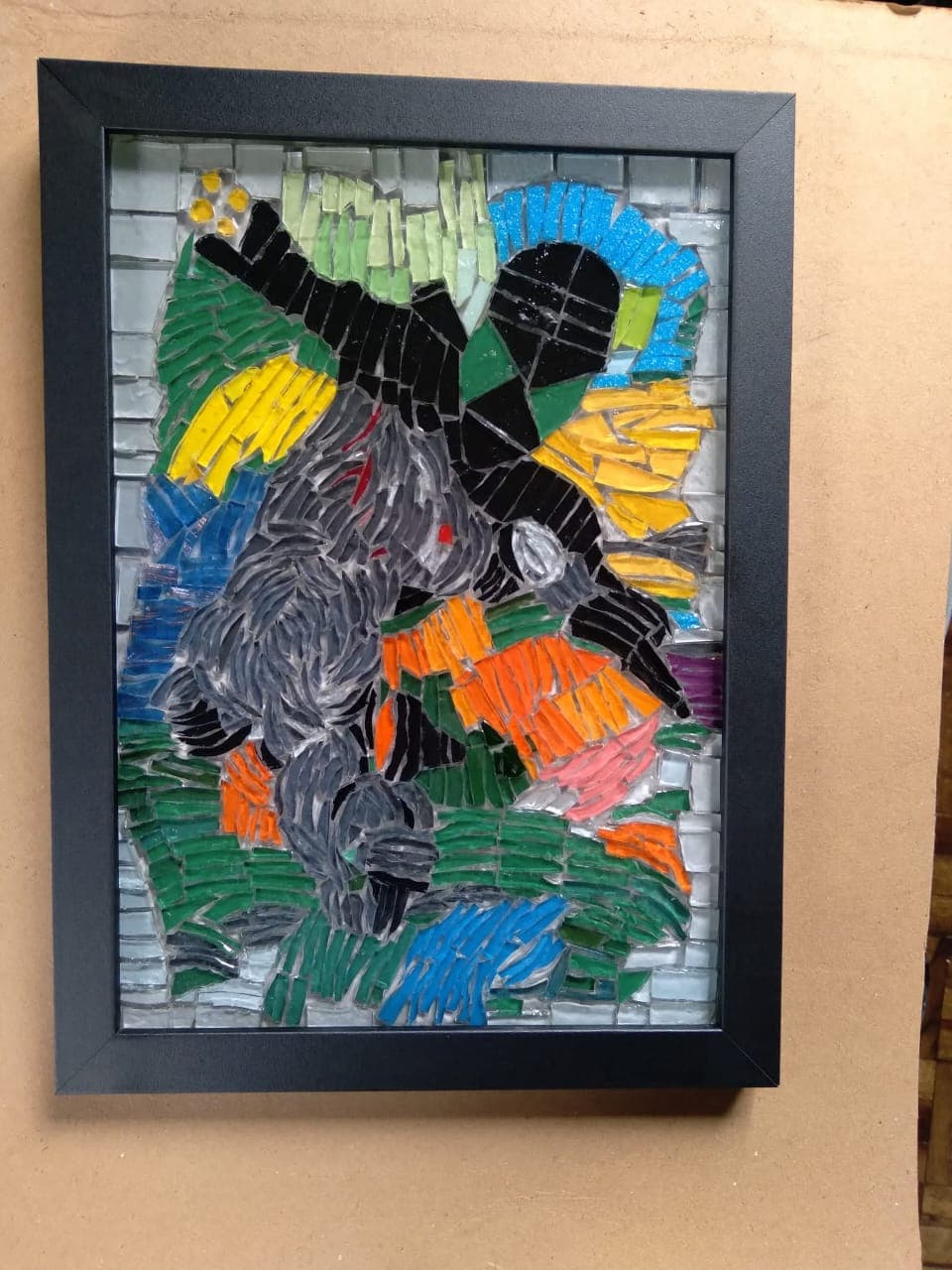 Obra em mosaico com cores intensas, montada em moldura preta, do acervo aprovado do artista.