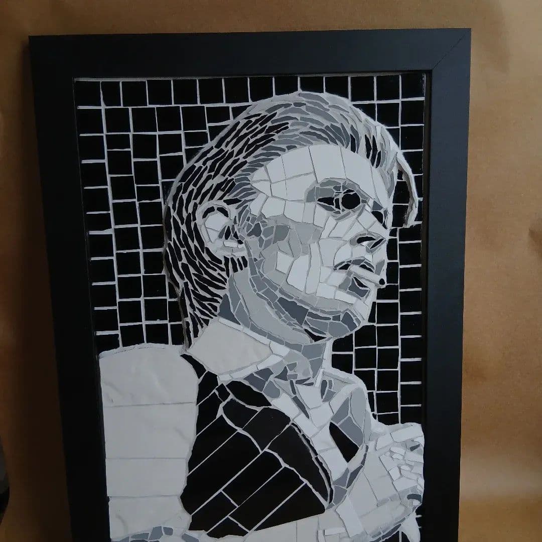 Retrato em mosaico em preto, branco e cinza do acervo aprovado do artista.